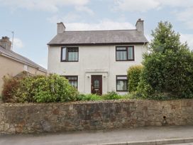 A house with a garden and stone wall at Fairfield in Llanbedrog