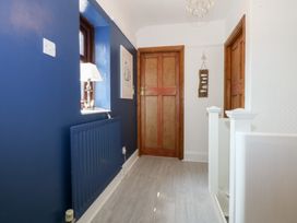 A hallway with a radiator and lamp at Fairfield in Llanbedrog