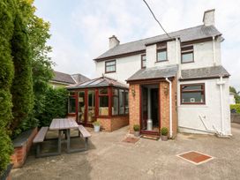 An outdoor area with a house and conservatory at Fairfield in Llanbedrog