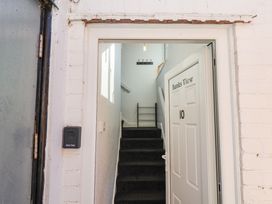 An entrance door labeled Banks View 10 opening to a staircase with black carpet and a coat rack on the wall at Banks View Filey