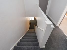 A carpeted staircase with white walls and a white banister at Banks View Filey in Filey