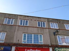 Upper floor windows of a building with signs for Ladbrokes and Overton below Banks View Filey