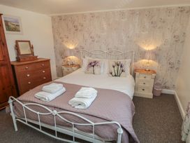 A bedroom with a bed and bedside tables at Bluebell Cottage in Flamborough
