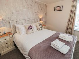 A bedroom with a bed and nightstand at Bluebell Cottage in Flamborough