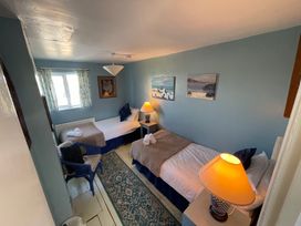 A bedroom with two beds and artwork on the walls at 11 Penygroes in Llanddeusant