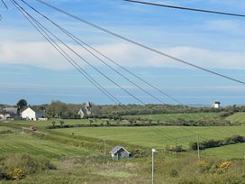 A landscape view with fields and a windmill at 11 Penygroes in Llanddeusant