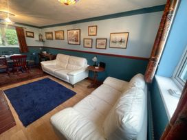 A living room with sofas and a dining area at 11 Penygroes in Llanddeusant