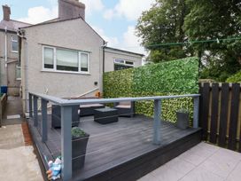 An outdoor area with a wooden deck and furniture at Y Berth in Caernarfon
