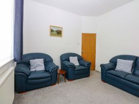 A living room with two sofas and a painting at Y Berth in Caernarfon