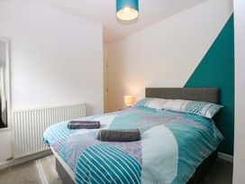 A bedroom with a bed and bedside lamp at Y Berth Caernarfon
