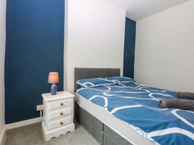 A bedroom with a bed and a bedside table at Y Berth in Caernarfon