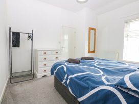 A bedroom with a bed and chest of drawers at Y Berth in Caernarfon