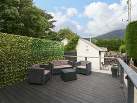 A seating area with chairs and a table surrounded by plants at Y Berth in Caernarfon