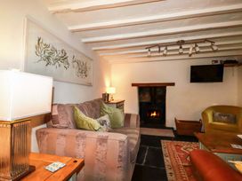 A living room with a sofa and a fireplace at Woodview in Looe