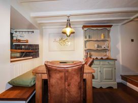 A dining room with a table and chairs at Woodview in Looe