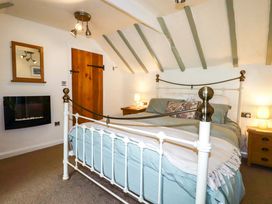 A bedroom with a bed and a fireplace at Woodview in Looe