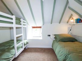 A bedroom with a bunk bed and a single bed at Woodview in Looe