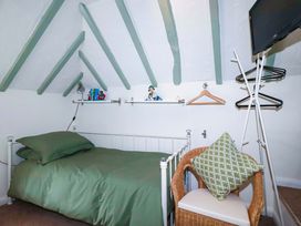 A bedroom with a bed and shelf at Woodview in Looe