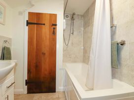 A bathroom featuring a bathtub and washbasin at Woodview, Looe