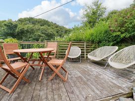 An outdoor area with a table and chairs at Woodview in Looe