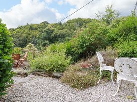 A garden with gravel path and chairs at Woodview in Looe