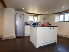 A kitchen with a refrigerator an island with cabinets and a countertop at Penpethy Farm in Tintagel