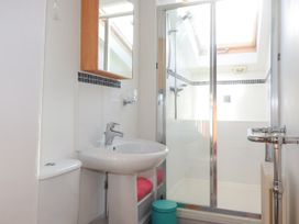 A bathroom with a sink toilet and shower area with glass door at Penpethy Farm in Tintagel