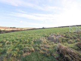 A grassy field with a small soccer goal and rolling countryside in the background at Penpethy Farm Tintagel