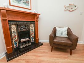 A living room with a fireplace and a chair at Maypole Cottage in Fylingthorpe