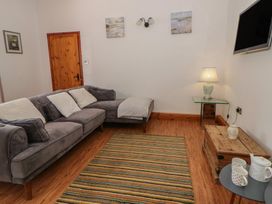 A living room with a sofa and a table at Swallows Retreat in Tenby
