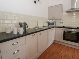 A kitchen with a sink and appliances at Swallows Retreat in Tenby