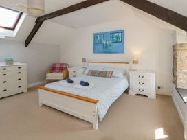 A bedroom with a bed and drawer units at Swallows Retreat in Tenby