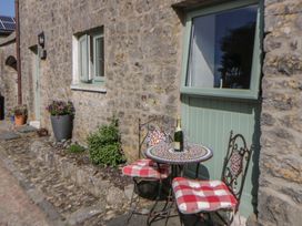 An outdoor seating area with a bistro table and chairs at Swallows Retreat in Tenby
