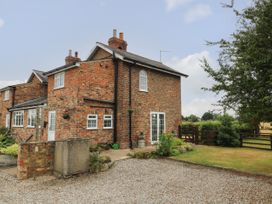 A brick house with a driveway and garden at 2 Crosslands in Stockton-On-The-Forest