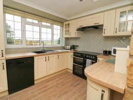 A kitchen with cream cabinets black appliances and wooden countertops at 2 Crosslands in Stockton-On-The-Forest