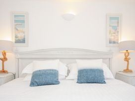 A bedroom with a bed with two pillows two table lamps and two framed pictures at Quay House in Charlestown