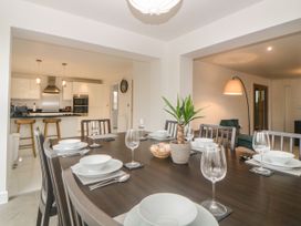 A dining table set with bowls and glasses in an open plan kitchen and living area at 2 White Rock Court in Paignton