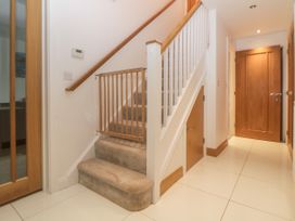 A hallway with carpeted stairs and wooden doors at 2 White Rock Court in Paignton