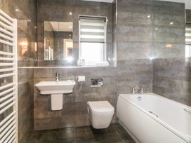 A bathroom with a sink toilet bathtub and radiator at 2 White Rock Court in Paignton