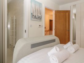 A bedroom with a bed with rolled towels and an open door leading to a hallway at 2 White Rock Court in Paignton