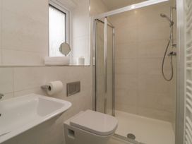 A bathroom with a sink toilet shower and a small window at 2 White Rock Court in Paignton