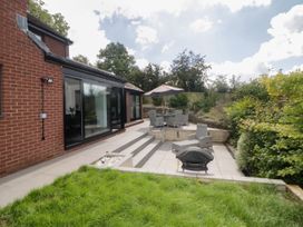 A garden patio with outdoor seating umbrella and barbecue near a brick house at 2 White Rock Court in Paignton