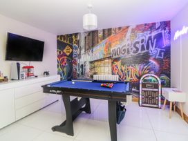 A game room with a pool table TV and a jukebox at 2 White Rock Court in Paignton