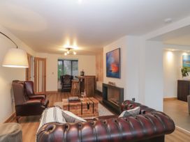 A living room with leather chairs wooden coffee table and a fireplace at 2 White Rock Court in Paignton