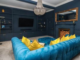 A living room with a blue sofa and a television at Kexby House