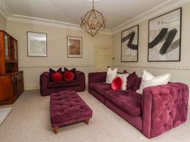 A living room with a purple sofa and ottoman at Kexby House 