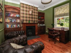 An office with a bookshelf and fireplace at Kexby House