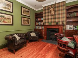 A study with brown chairs and a fireplace at Kexby House