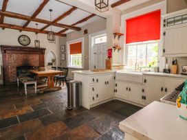 A kitchen with a table and chairs near a fireplace at Kexby House