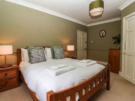 A bedroom with a bed and nightstands at Kexby House